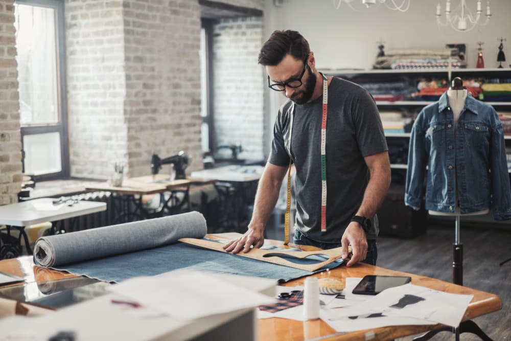 Designer cutting denim in the Square Denims design studio